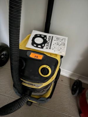 un aspirateur jaune et noir posé par terre à côté d'un livre