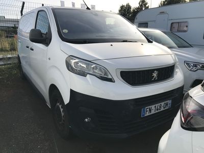 une camionnette blanche garée à côté d'autres voitures