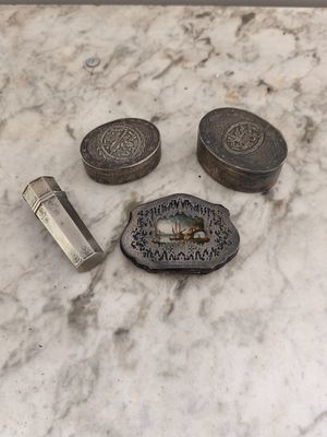un petit objet métallique posé sur une table en marbre, à côté d'autres objets