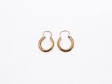a pair of gold hoop earrings on a white background