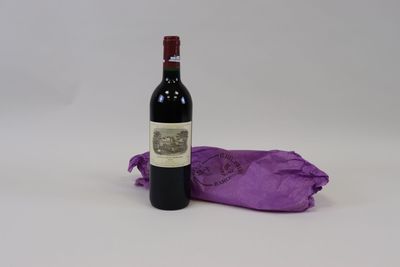une bouteille de vin posée à côté d'un sac violet