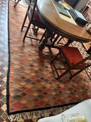 une table et des chaises dans une pièce avec un tapis au sol