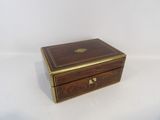 an antique wooden box with brass trims and a lid