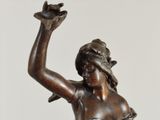 bronze statue of a woman holding a bird in her hand