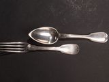 two spoons and a fork on a black surface