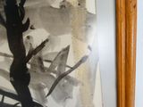 une photo d'un tableau accroché au mur, à côté d'un bâton en bois