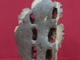 sculpture of a rock with holes in it on a red surface