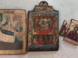 two old religious paintings are sitting on the floor next to each other