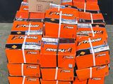 une palette remplie de cartons orange posée sur une autre palette