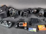 de nombreux appareils photo et accessoires de toutes sortes disposés sur la table