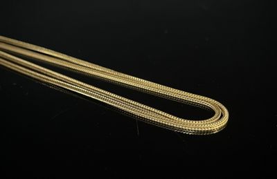 a close up of a gold chain on a black surface