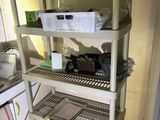 a kitchen with a stove, sink, microwave, and shelves