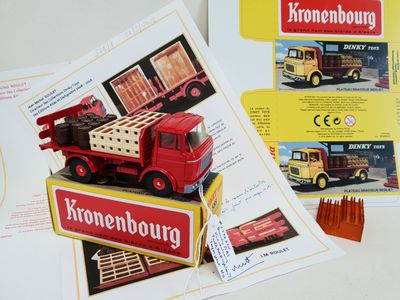 a red toy truck sitting on top of a book
