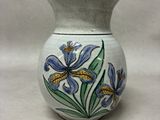 a white vase with blue and yellow flowers on it