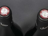two bottles of wine sitting next to each other on a table