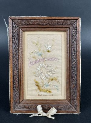 Une broderie d'anniversaire dans un cadre en bois sculpté