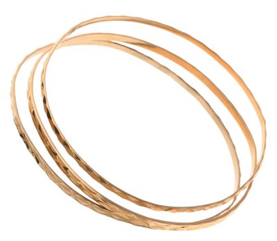 un gros plan sur une pile de bracelets rigides en or sur fond blanc