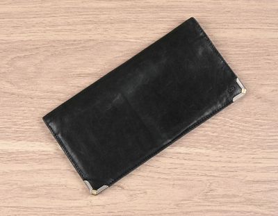 leather wallet on a wooden table with a white background
