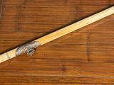 a wooden stick with a metal handle on a wooden floor