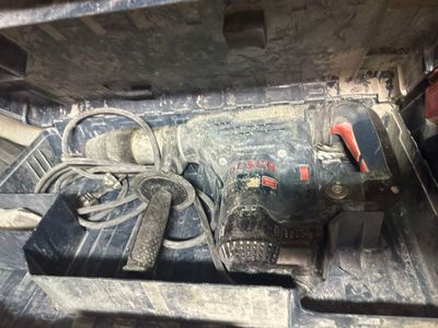 a drill in the back of a truck with tools in it