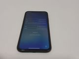 the back of a black phone sitting on top of a white table
