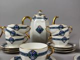 a tea set with a teapot, cups, and saucers on a table