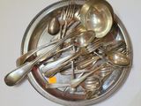 de nombreuses cuillères et fourchettes en argent posées sur un plateau en argent