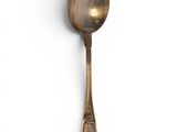 a silver spoon with a spoon handle on a white surface