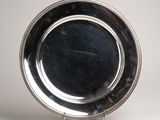 an antique silver plate on a stand on a white background
