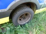 a blue truck with a yellow stripe parked in the grass