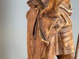 wooden statue of a man with a cane and a hat
