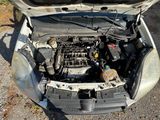 the engine of a car with its hood open on a gravel road