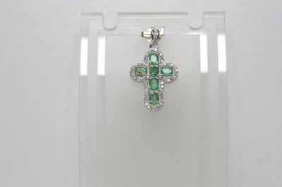 un gros plan d'un pendentif en forme de croix dans une vitrine transparente