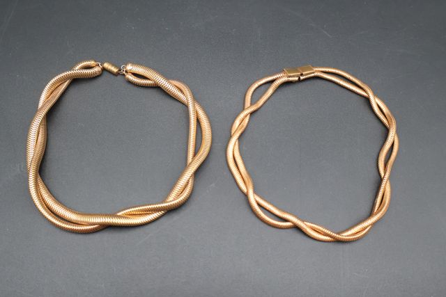 Lot de deux colliers souples en métal doré.