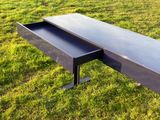 un banc noir posé au milieu de la pelouse