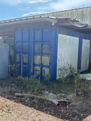un immeuble bleu devant lequel s'entassent beaucoup de déchets