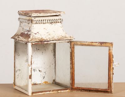 une petite lanterne blanche posée sur une table en bois