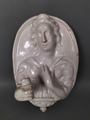 une statue représentant une femme tenant un panier rempli de nourriture