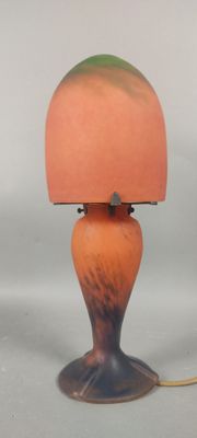 une lampe orange surmontée d'un abat-jour vert