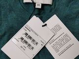 two tags on a sweater hang on a hanger on a hanger