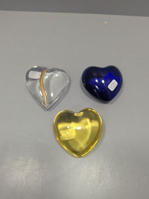 trois objets en verre en forme de cœur posés sur la table
