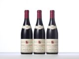 three bottles of red wine sitting on top of a table