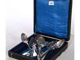 four spoons in a black case on a white surface