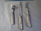 three knives and a fork on a table