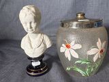 a vase with a bust of a woman next to a vase with flowers on it