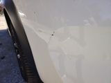 a close up of a white car with a hole in the side