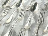 many forks and spoons that are wrapped in plastic