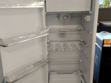 a white refrigerator with its door open in a kitchen