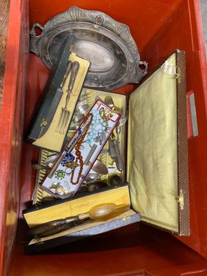 a red box filled with assorted items on the ground