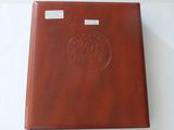 a brown leather album with a circular design on the cover